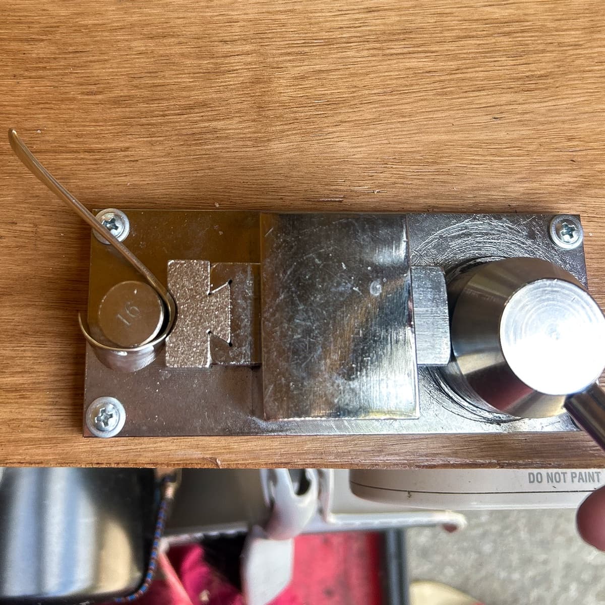 A spoon handle being bent around a ring mandrel on the workbench